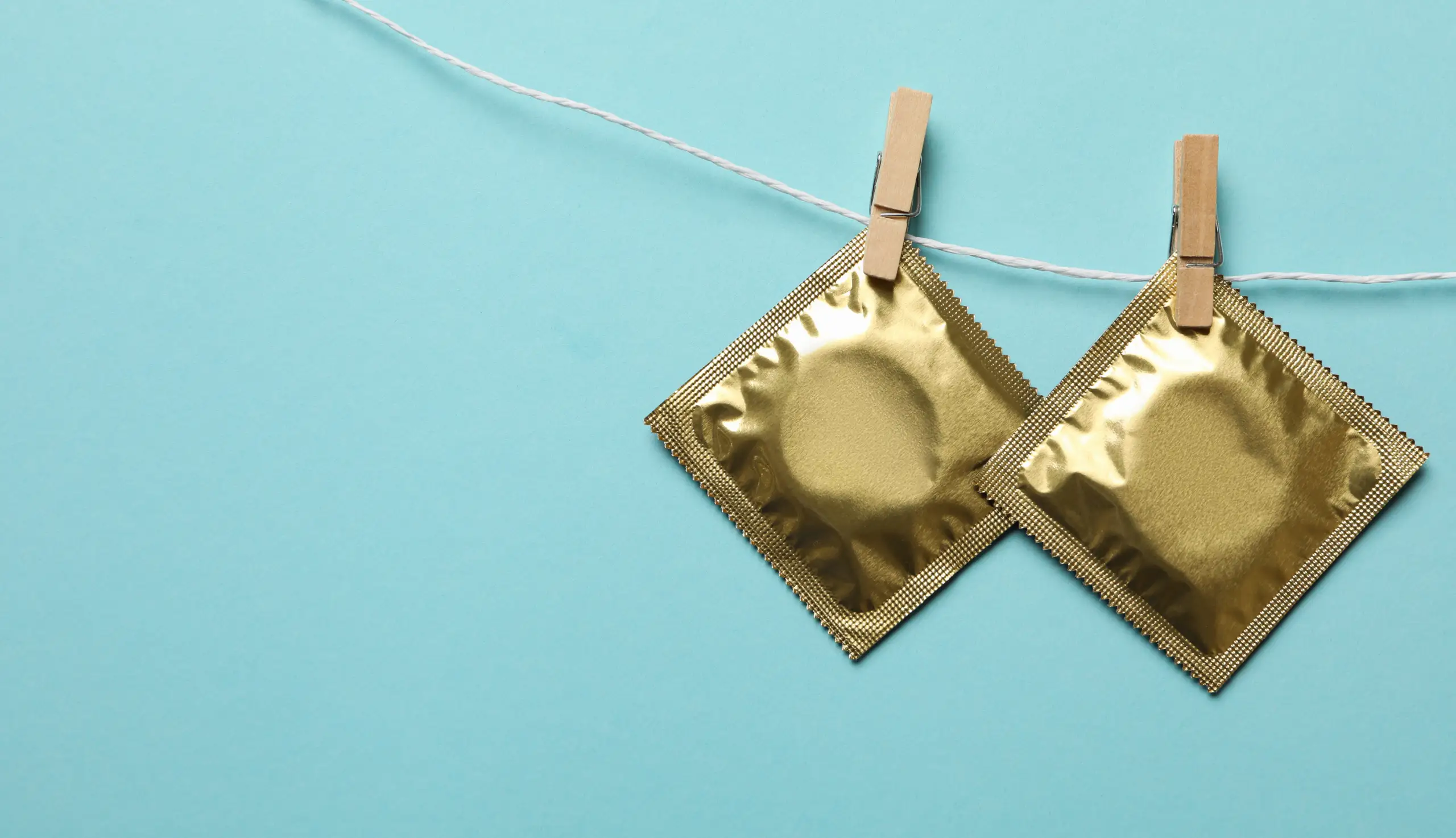 Preservativos pendurados em um varal.